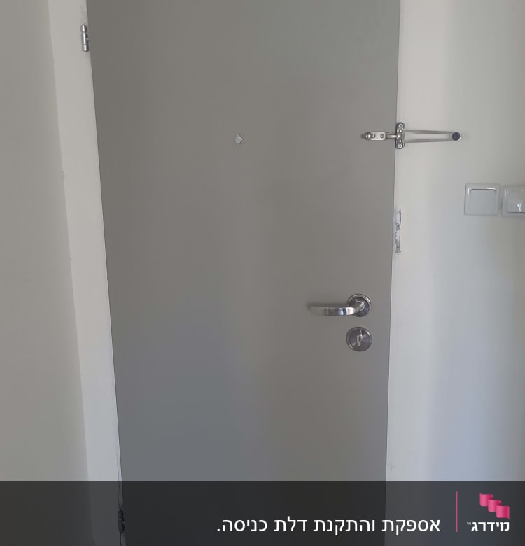 דלת אפורה עם ידית מתכת ובריח בטיחות